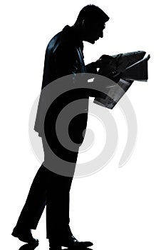 Silhouette man walking newspaper full length