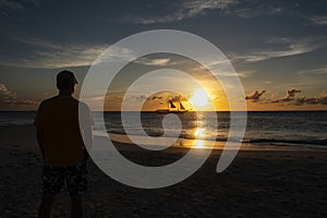 Silhouette of a Man Watching Sunset Over the Ocean