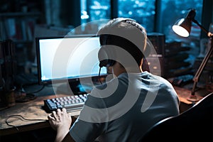 Silhouette of a man working on a computer, facing away