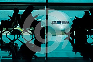 Silhouette of many Passengers Waiting for Boarding in Departure Terminal in the Airport