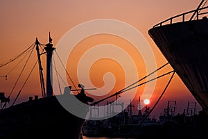 Silhouette many ships moored along the coast against colorful sunset sky background in evening time