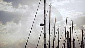 Silhouette masts against cloudscape