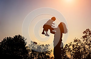 Silhouette of mather with her toddler against the sunset