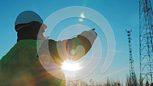 Silhouette mature engineer working with satellite dish telecom network in telecommunication tower on background.