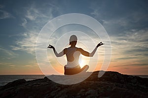 Silhouette meditation girl on the background of the sea and sunset.