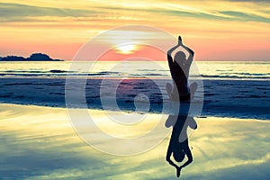 Silhouette meditation yoga woman of sunset sea.