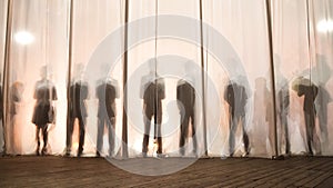 The silhouette of the men behind the curtain in the theater on stage, the shadow behind the scenes is similar to the white and bla