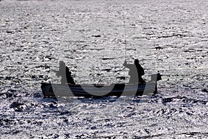 Silhouette of a men fishing from a small boat