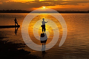 Silhouette, men standing, fishing At the Mekong River at sunset