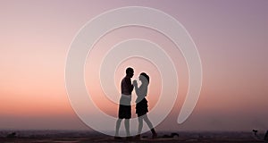 Silhouette of couple feeling love at sunset photo