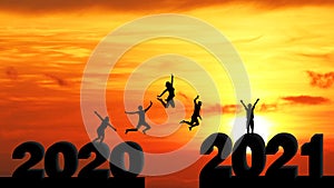 Silhouette of men and women jumping from 2020 to 2021. Happy new year