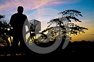 Silhouette Middle-aged man exercise by bicycle in twilight time