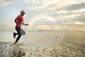 Silhouette of middle aged woman running on the beach - 40s or 50s attractive mature lady doing jogging workout enjoying fitness