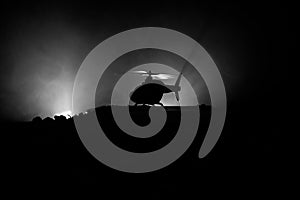 Silhouette of military helicopter ready to fly from conflict zone. Decorated night footage with helicopter starting in desert with
