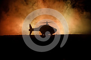 Silhouette of military helicopter ready to fly from conflict zone. Decorated night footage with helicopter starting in desert with