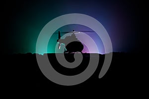 Silhouette of military helicopter ready to fly from conflict zone. Decorated night footage with helicopter starting in desert with