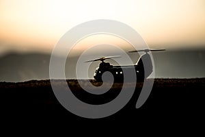 Silhouette of military helicopter ready to fly from conflict zone. Decorated night footage with helicopter starting in desert with