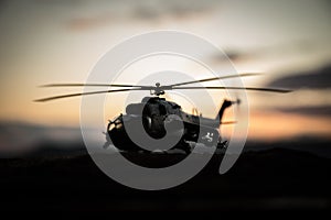 Silhouette of military helicopter ready to fly from conflict zone. Decorated night footage with helicopter starting in desert with