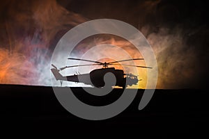 Silhouette of military helicopter ready to fly from conflict zone. Decorated night footage with helicopter starting in desert with