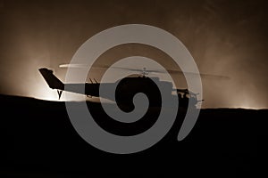 Silhouette of military helicopter ready to fly from conflict zone. Decorated night footage with helicopter starting in desert with