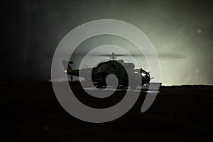 Silhouette of military helicopter ready to fly from conflict zone. Decorated night footage with helicopter starting in desert with