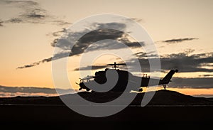 Silhouette of military helicopter ready to fly from conflict zone. Decorated night footage with helicopter starting in desert with