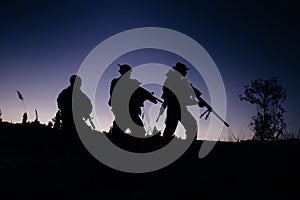 Silhouette of military soldiers with weapons at night. shot, holding gun, colorful sky. .