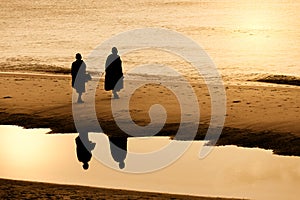 Silhouette of monk walking on Huahin beach