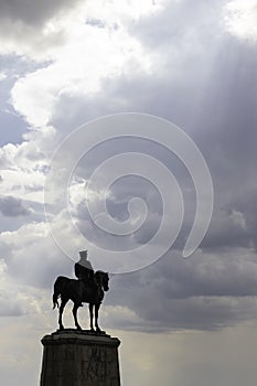 Silhouette of monument of Ataturk with cloudy sky and sunrays between the clouds