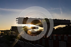 Silhouette with morning sun rays on highway overpass bridge infrastructure under construction