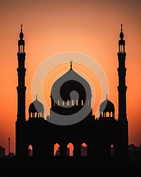Dawn silhouette of mosque illuminated by first light