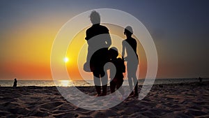 Silhouette of mother and children walking on beach