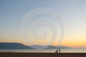 Silhouette of mother with stroller enjoying motherhood at sunset