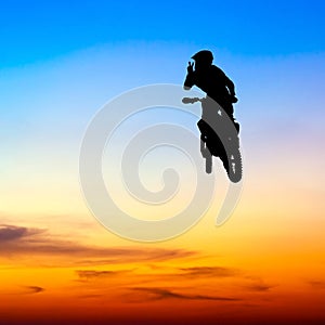 Silhouette of motocross rider jump in the sky