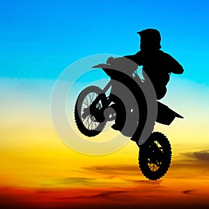 Silhouette of motocross rider jump in the sky