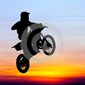 Silhouette of motocross rider jump in the sky