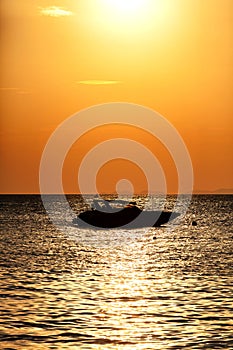 Silhouette of a motor speed boat at sunset