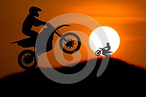 Silhouette of Motorbike rider jump cross slope of mountain with