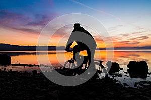 Silhouette of a mountain bike and cyclist at sunrise