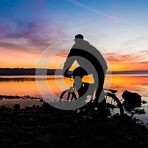 Silhouette of a mountain bike and cyclist at sunrise