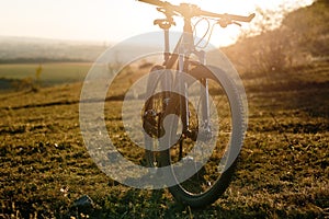 Silhouette of Mountain bike on the meadow at sunset