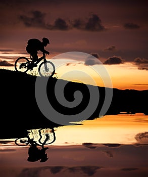 Silhouette of mountain biker with Reflection