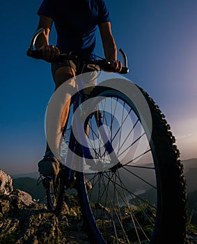 Silhouette of a mountain biker riding his mountain sportbike on top of a cliff  hill