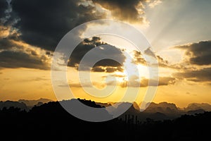 Silhouette of mountain and orange summer sunset background.