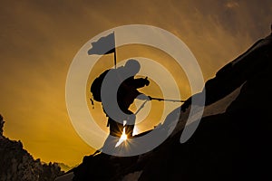 Silhouette of mountaineer and sunset.