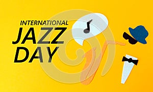 Silhouette of a musician with a saxophone from which melodie flew out, on a yellow background, cutted out of felt. Flat lay.