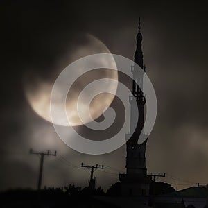 Silhouette of Muslim Mosque under full moon light sky in dark night