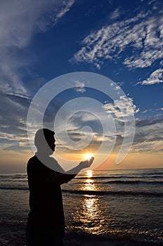 Silhouette of Muslim pray near the beach