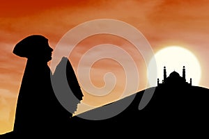 Silhouette of muslim woman praying near mosque