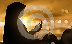 Silhouette of muslim woman praying with prayer beads